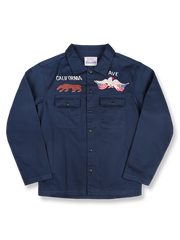 製品画像
厚手キャンバス生地で作られた刺繍キャンバスシャツの全体画像。1960年代のミリタリーユニフォームを再現したヴィンテージ感あるデザインが特徴。
詳細画像
フランス・ペリグーとアメリカ・カリフォルニア州をモチーフにした繊細な刺繍ディテールのクローズアップ。実用的なフラップ付きポケットも強調。