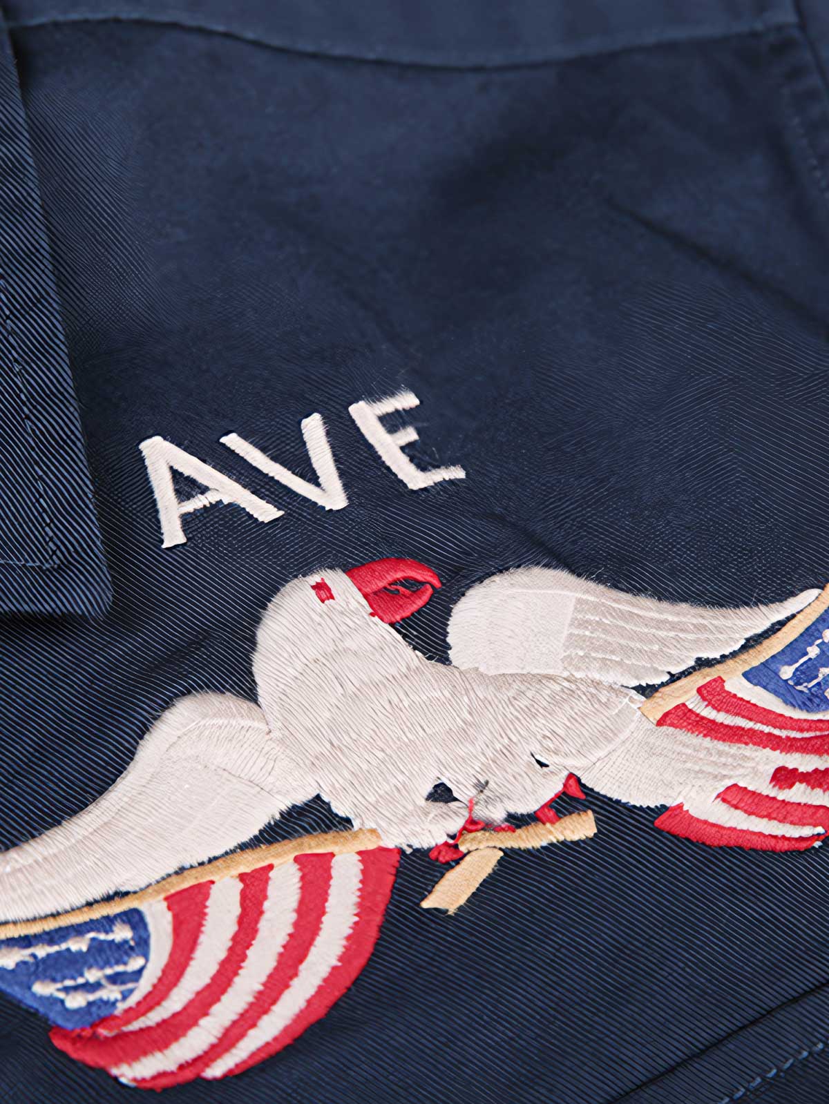 製品画像
厚手キャンバス生地で作られた刺繍キャンバスシャツの全体画像。1960年代のミリタリーユニフォームを再現したヴィンテージ感あるデザインが特徴。
詳細画像
フランス・ペリグーとアメリカ・カリフォルニア州をモチーフにした繊細な刺繍ディテールのクローズアップ。実用的なフラップ付きポケットも強調。