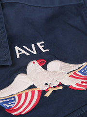 製品画像
厚手キャンバス生地で作られた刺繍キャンバスシャツの全体画像。1960年代のミリタリーユニフォームを再現したヴィンテージ感あるデザインが特徴。
詳細画像
フランス・ペリグーとアメリカ・カリフォルニア州をモチーフにした繊細な刺繍ディテールのクローズアップ。実用的なフラップ付きポケットも強調。