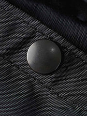 製品画像
1960年代のUSAFナイロンヘルメットバッグをリバイバルしたデザインの全体画像。防水性を備えた高密度ナイロン素材と多機能収納ポケットを特徴とするクラシカルなミリタリーバッグ。
詳細画像
フロント部分の立体収納ポケット、金属製フック、YKK製ナイロンファスナー、そしてキルティング加工された内部の中綿ディテールを強調したクローズアップ画像。