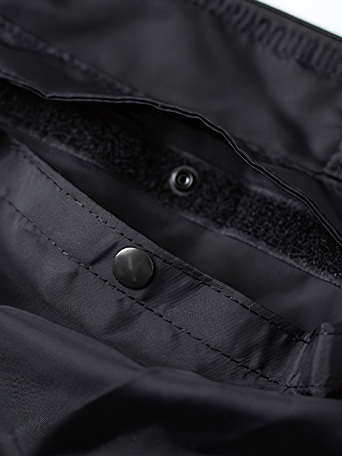 製品画像
1960年代のUSAFナイロンヘルメットバッグをリバイバルしたデザインの全体画像。防水性を備えた高密度ナイロン素材と多機能収納ポケットを特徴とするクラシカルなミリタリーバッグ。
詳細画像
フロント部分の立体収納ポケット、金属製フック、YKK製ナイロンファスナー、そしてキルティング加工された内部の中綿ディテールを強調したクローズアップ画像。