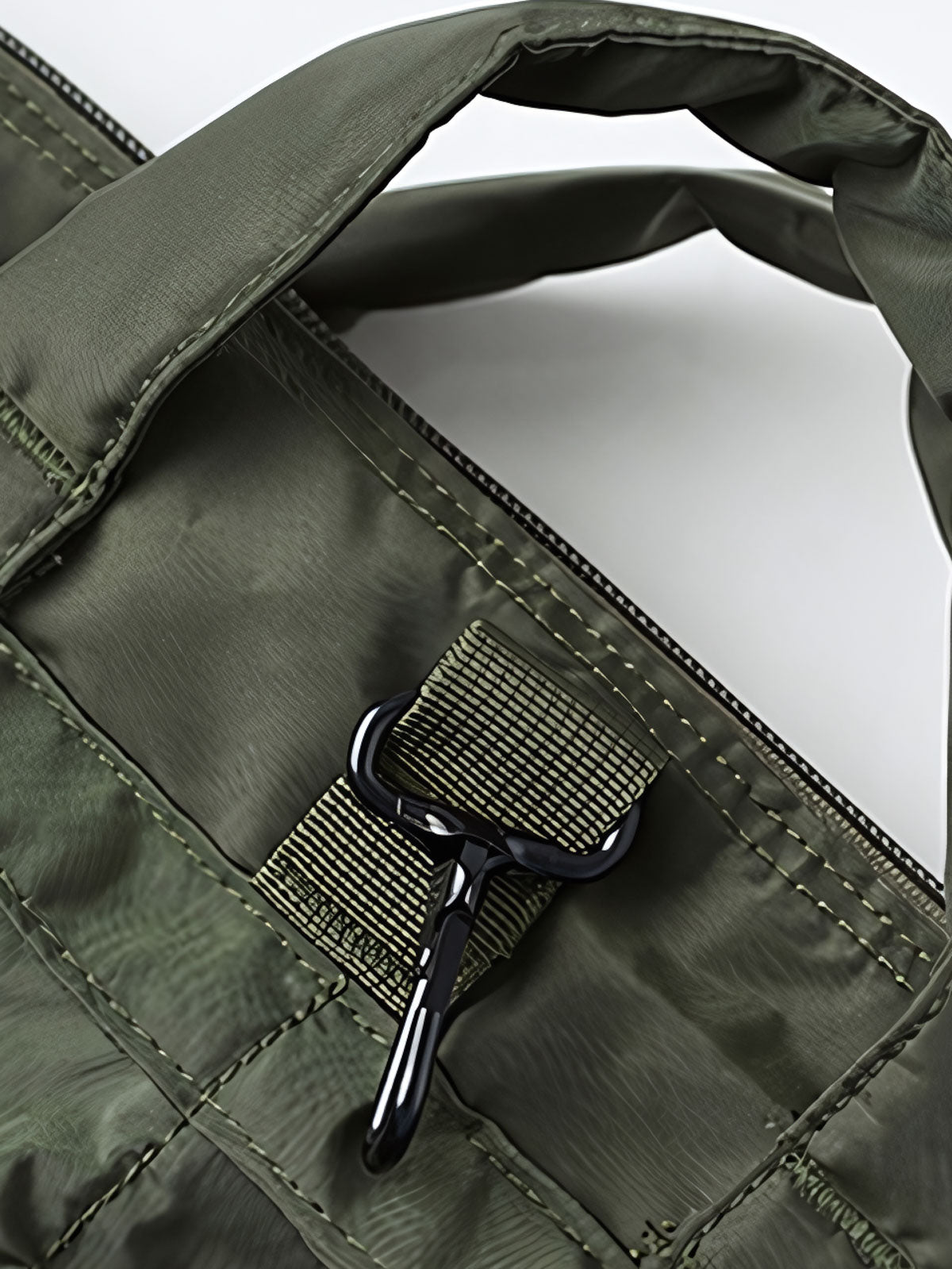 製品画像
1960年代のUSAFナイロンヘルメットバッグをリバイバルしたデザインの全体画像。防水性を備えた高密度ナイロン素材と多機能収納ポケットを特徴とするクラシカルなミリタリーバッグ。
詳細画像
フロント部分の立体収納ポケット、金属製フック、YKK製ナイロンファスナー、そしてキルティング加工された内部の中綿ディテールを強調したクローズアップ画像。