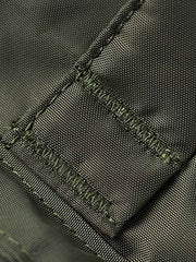 製品画像
1960年代のUSAFナイロンヘルメットバッグをリバイバルしたデザインの全体画像。防水性を備えた高密度ナイロン素材と多機能収納ポケットを特徴とするクラシカルなミリタリーバッグ。
詳細画像
フロント部分の立体収納ポケット、金属製フック、YKK製ナイロンファスナー、そしてキルティング加工された内部の中綿ディテールを強調したクローズアップ画像。