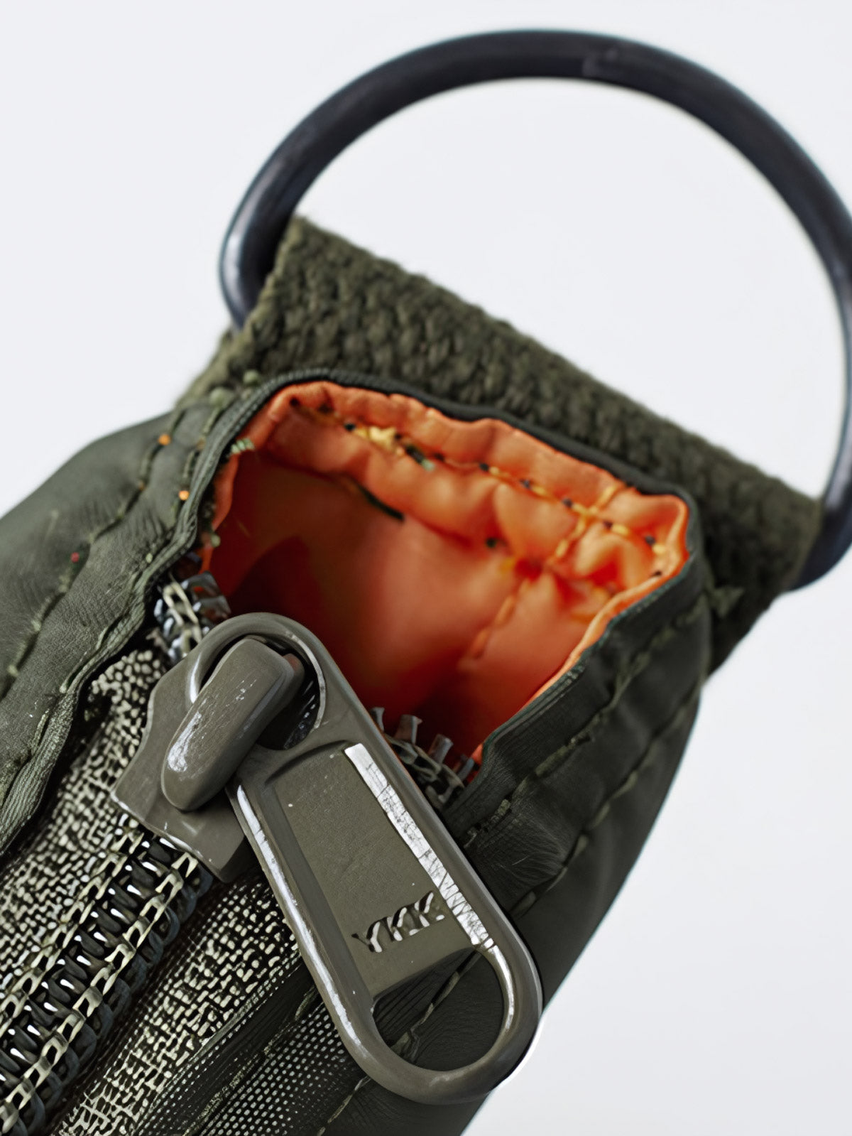 製品画像
1960年代のUSAFナイロンヘルメットバッグをリバイバルしたデザインの全体画像。防水性を備えた高密度ナイロン素材と多機能収納ポケットを特徴とするクラシカルなミリタリーバッグ。
詳細画像
フロント部分の立体収納ポケット、金属製フック、YKK製ナイロンファスナー、そしてキルティング加工された内部の中綿ディテールを強調したクローズアップ画像。