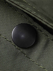 製品画像
1960年代のUSAFナイロンヘルメットバッグをリバイバルしたデザインの全体画像。防水性を備えた高密度ナイロン素材と多機能収納ポケットを特徴とするクラシカルなミリタリーバッグ。
詳細画像
フロント部分の立体収納ポケット、金属製フック、YKK製ナイロンファスナー、そしてキルティング加工された内部の中綿ディテールを強調したクローズアップ画像。