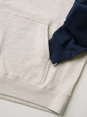 製品画像
430gの厚手スウェット生地で作られたバイカラー ラグランスリーブ パーカー全体画像。ヴィンテージカレッジ風のデザインが特徴で、秋冬の万能アイテムとして活躍。
詳細画像
肩周りをすっきり見せるラグランスリーブデザインと、縫製部分を補強した三本針ステッチのクローズアップ画像。厚手リブ仕様のディテールも確認可能。