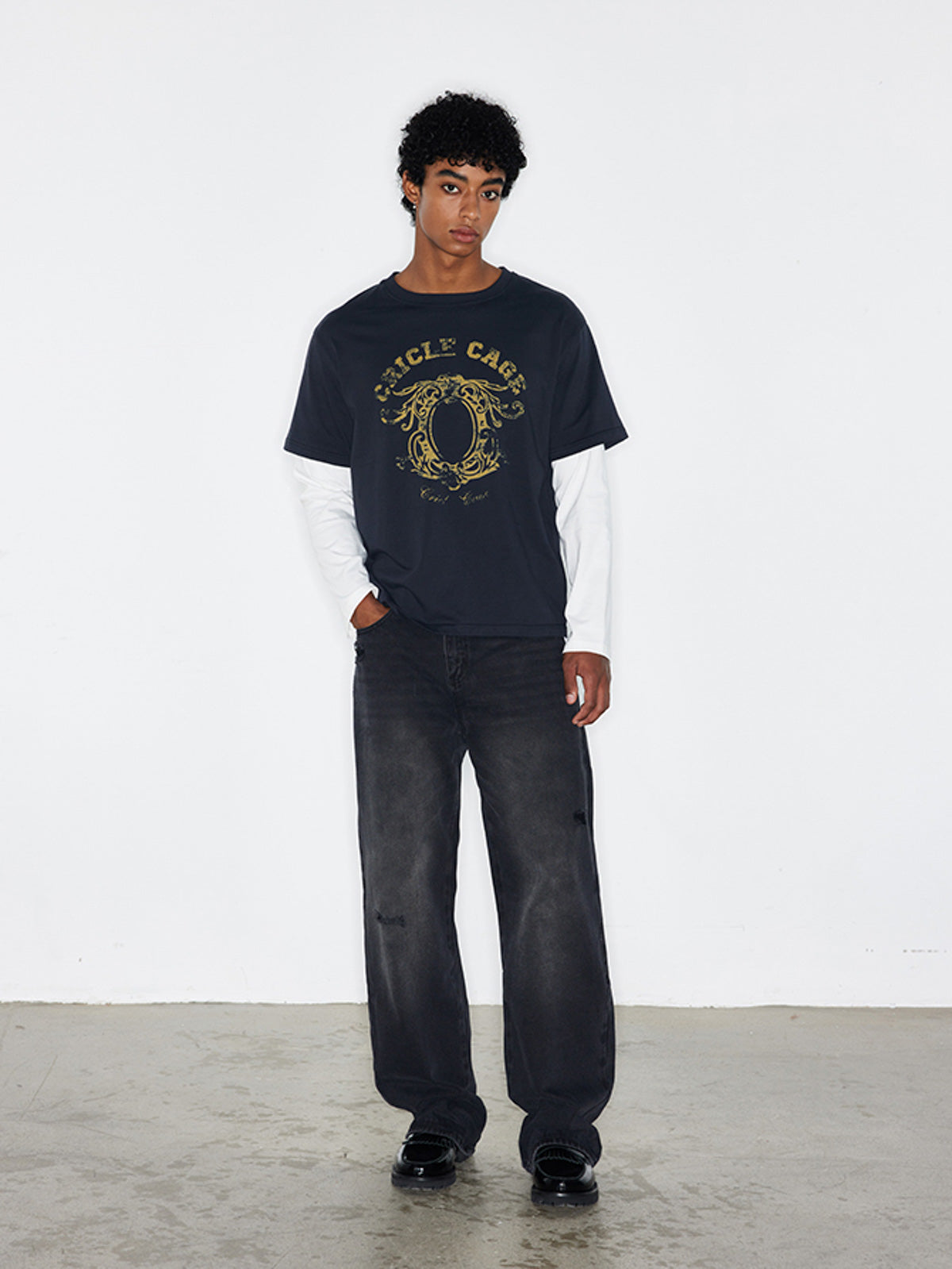 モデル画像:モデルがヴィンテージ加工プリントレイヤード風長袖Tシャツを着用