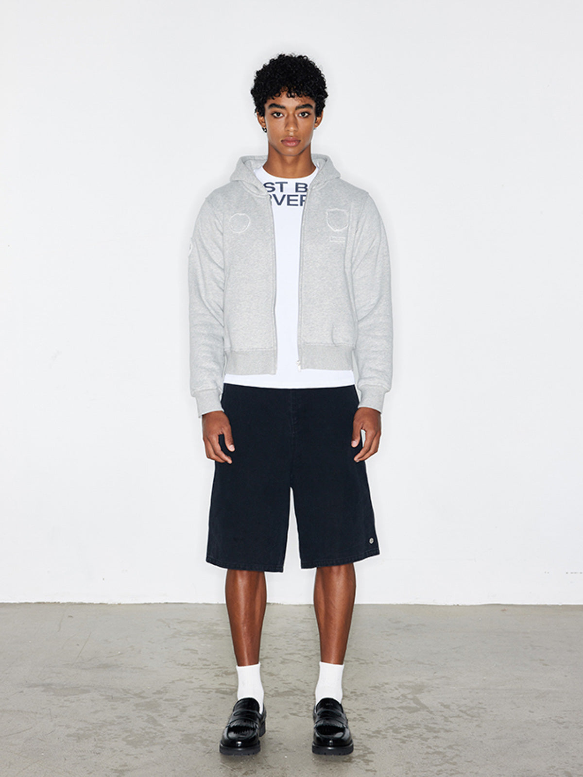 モデルがバッジパッチ付きフード付きジップアップパーカーを着用した画像