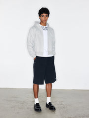 モデルがバッジパッチ付きフード付きジップアップパーカーを着用した画像