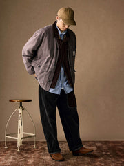 詳細画像
「ヘリンボーン生地のしっかりとしたテクスチャーとウォッシュ加工によるユーズド感、胸ポケットのラムウール織りディテールをクローズアップ。」
モデル画像
「インナーにシャツを合わせて着用したノーカラーフィッシングジャケット。ルーズフィットのシルエットがレイヤードスタイルを引き立てるヴィンテージ風コーディネート。」