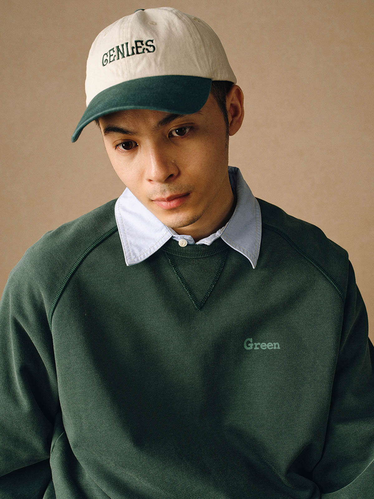 詳細画像
「胸元の英文字プリントとスノーウォッシュ加工による色落ち感が際立つ生地のディテールクローズアップ。柔らかな肌触りと褪色の質感が魅力。」
モデル画像
「モデルがピンクベージュの色落ち加工スウェットを着用し、カジュアルパンツと合わせたレトロでスポーティなヴィンテージ風コーディネート。」