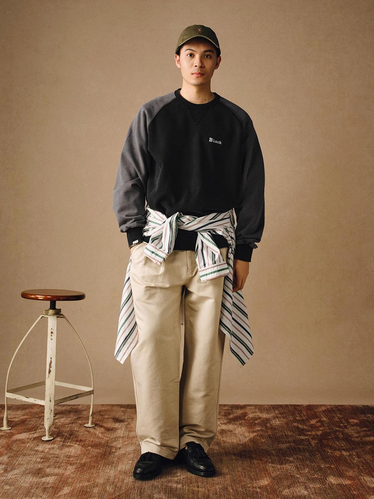 詳細画像
「胸元の英文字プリントとスノーウォッシュ加工による色落ち感が際立つ生地のディテールクローズアップ。柔らかな肌触りと褪色の質感が魅力。」
モデル画像
「モデルがピンクベージュの色落ち加工スウェットを着用し、カジュアルパンツと合わせたレトロでスポーティなヴィンテージ風コーディネート。」