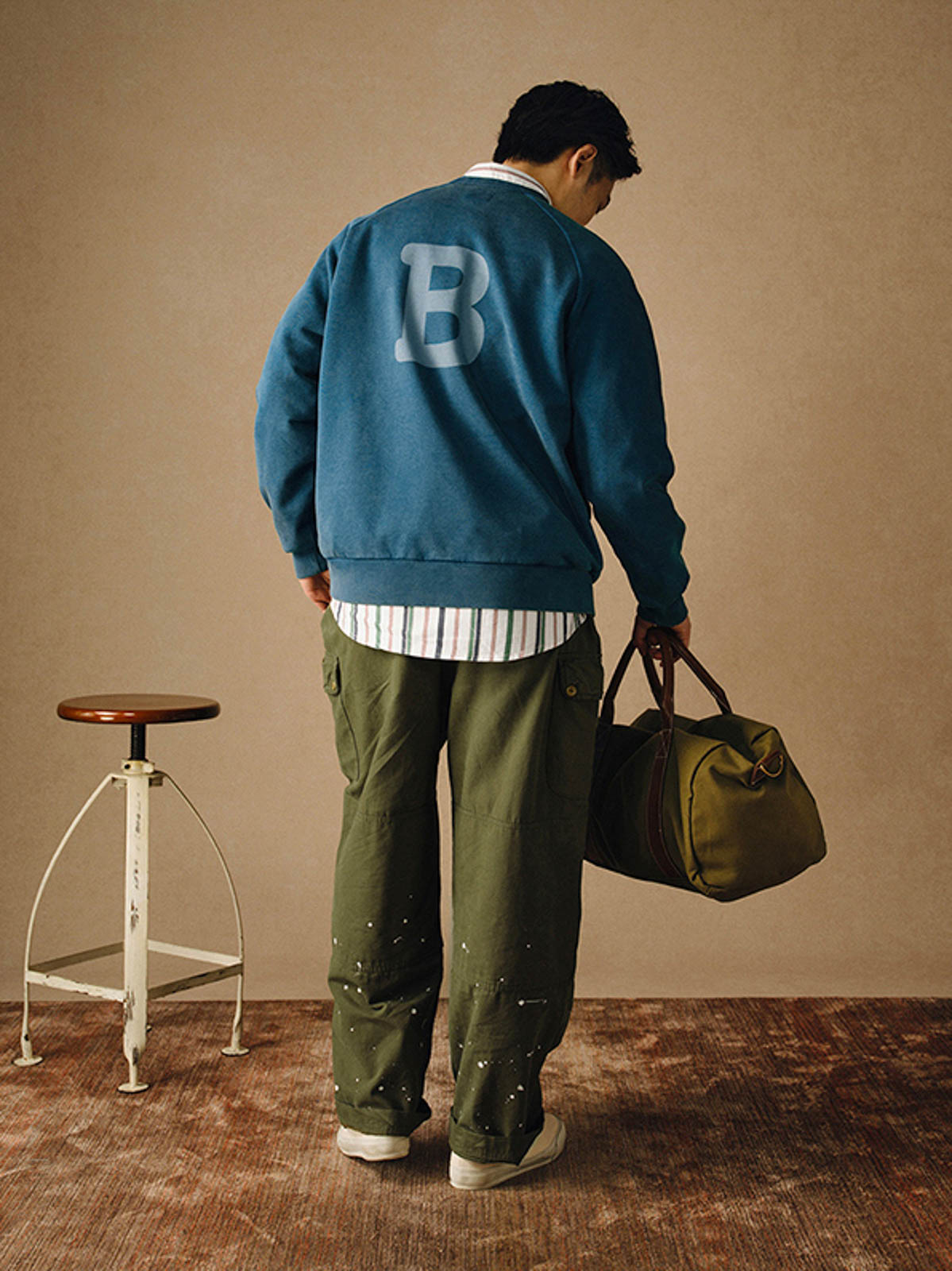 詳細画像
「胸元の英文字プリントとスノーウォッシュ加工による色落ち感が際立つ生地のディテールクローズアップ。柔らかな肌触りと褪色の質感が魅力。」
モデル画像
「モデルがピンクベージュの色落ち加工スウェットを着用し、カジュアルパンツと合わせたレトロでスポーティなヴィンテージ風コーディネート。」