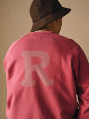 詳細画像
「胸元の英文字プリントとスノーウォッシュ加工による色落ち感が際立つ生地のディテールクローズアップ。柔らかな肌触りと褪色の質感が魅力。」
モデル画像
「モデルがピンクベージュの色落ち加工スウェットを着用し、カジュアルパンツと合わせたレトロでスポーティなヴィンテージ風コーディネート。」