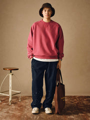 詳細画像
「胸元の英文字プリントとスノーウォッシュ加工による色落ち感が際立つ生地のディテールクローズアップ。柔らかな肌触りと褪色の質感が魅力。」
モデル画像
「モデルがピンクベージュの色落ち加工スウェットを着用し、カジュアルパンツと合わせたレトロでスポーティなヴィンテージ風コーディネート。」