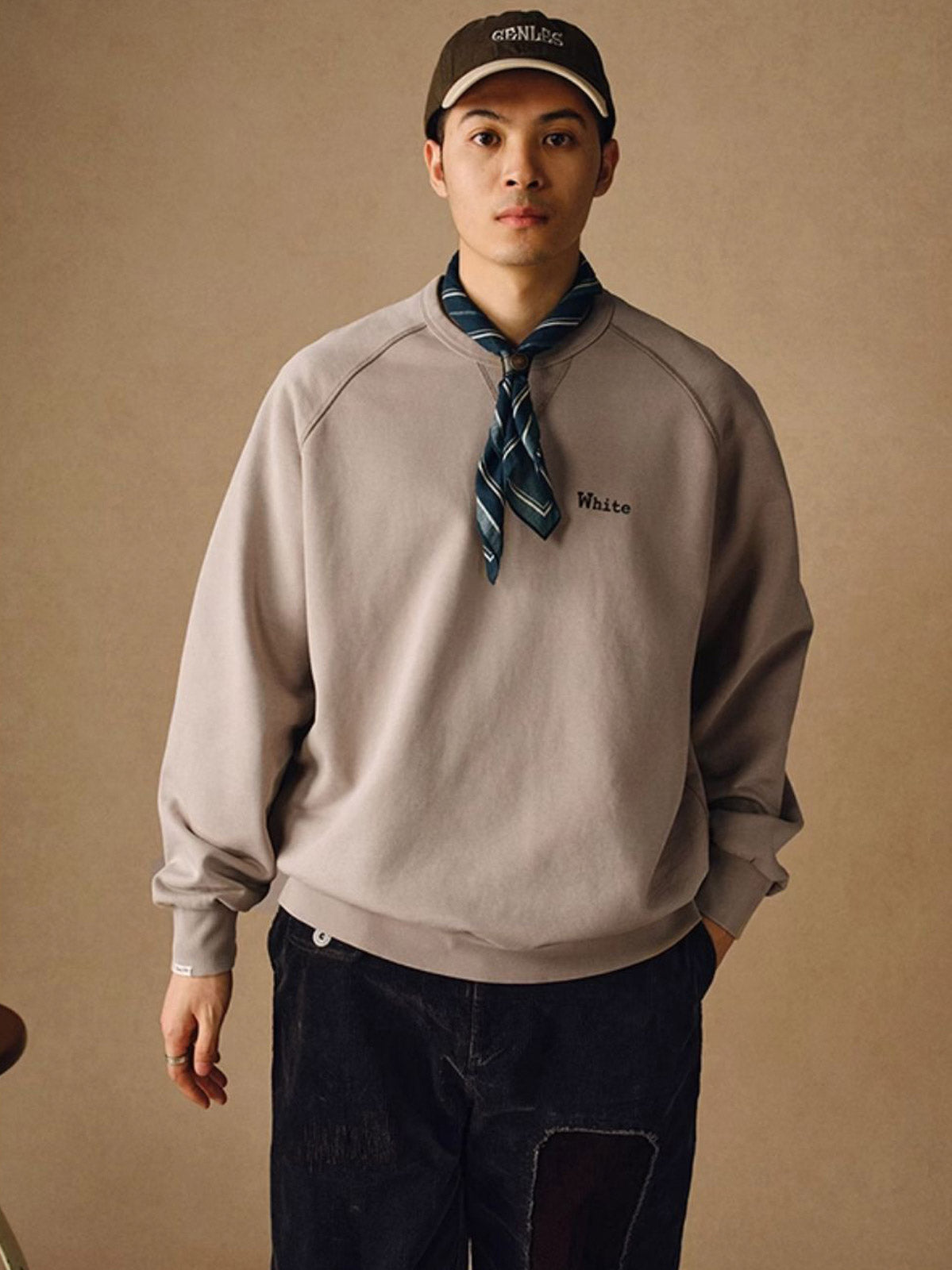 詳細画像
「胸元の英文字プリントとスノーウォッシュ加工による色落ち感が際立つ生地のディテールクローズアップ。柔らかな肌触りと褪色の質感が魅力。」
モデル画像
「モデルがピンクベージュの色落ち加工スウェットを着用し、カジュアルパンツと合わせたレトロでスポーティなヴィンテージ風コーディネート。」