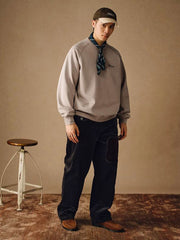 詳細画像
「胸元の英文字プリントとスノーウォッシュ加工による色落ち感が際立つ生地のディテールクローズアップ。柔らかな肌触りと褪色の質感が魅力。」
モデル画像
「モデルがピンクベージュの色落ち加工スウェットを着用し、カジュアルパンツと合わせたレトロでスポーティなヴィンテージ風コーディネート。」