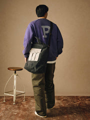 詳細画像
「胸元の英文字プリントとスノーウォッシュ加工による色落ち感が際立つ生地のディテールクローズアップ。柔らかな肌触りと褪色の質感が魅力。」
モデル画像
「モデルがピンクベージュの色落ち加工スウェットを着用し、カジュアルパンツと合わせたレトロでスポーティなヴィンテージ風コーディネート。」