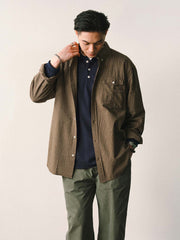 詳細画像
「胸元のユニークな配置のパッチポケットと立体感のあるチェック柄生地のディテールをクローズアップ。シワになりにくい特性も備えた高品質なコットン素材。」
モデル画像
「モデルがネイビーのチェック柄パッチポケットシャツを着用し、デニムパンツと合わせたカジュアルなコーディネートを披露。」