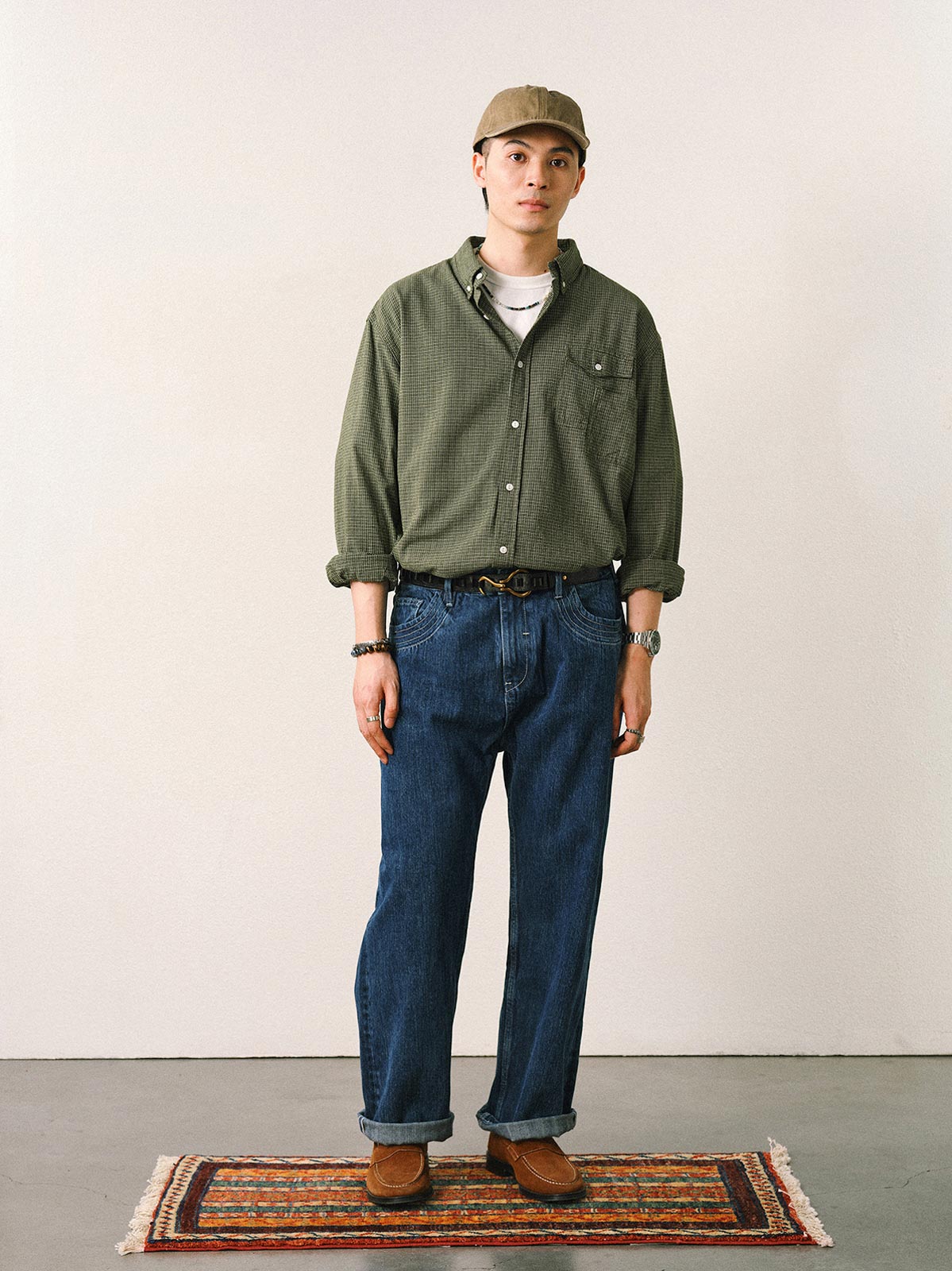 詳細画像
「胸元のユニークな配置のパッチポケットと立体感のあるチェック柄生地のディテールをクローズアップ。シワになりにくい特性も備えた高品質なコットン素材。」
モデル画像
「モデルがネイビーのチェック柄パッチポケットシャツを着用し、デニムパンツと合わせたカジュアルなコーディネートを披露。」