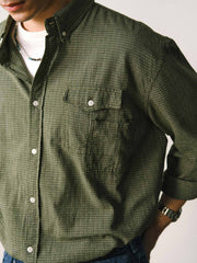 詳細画像
「胸元のユニークな配置のパッチポケットと立体感のあるチェック柄生地のディテールをクローズアップ。シワになりにくい特性も備えた高品質なコットン素材。」
モデル画像
「モデルがネイビーのチェック柄パッチポケットシャツを着用し、デニムパンツと合わせたカジュアルなコーディネートを披露。」