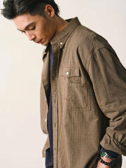 詳細画像
「胸元のユニークな配置のパッチポケットと立体感のあるチェック柄生地のディテールをクローズアップ。シワになりにくい特性も備えた高品質なコットン素材。」
モデル画像
「モデルがネイビーのチェック柄パッチポケットシャツを着用し、デニムパンツと合わせたカジュアルなコーディネートを披露。」