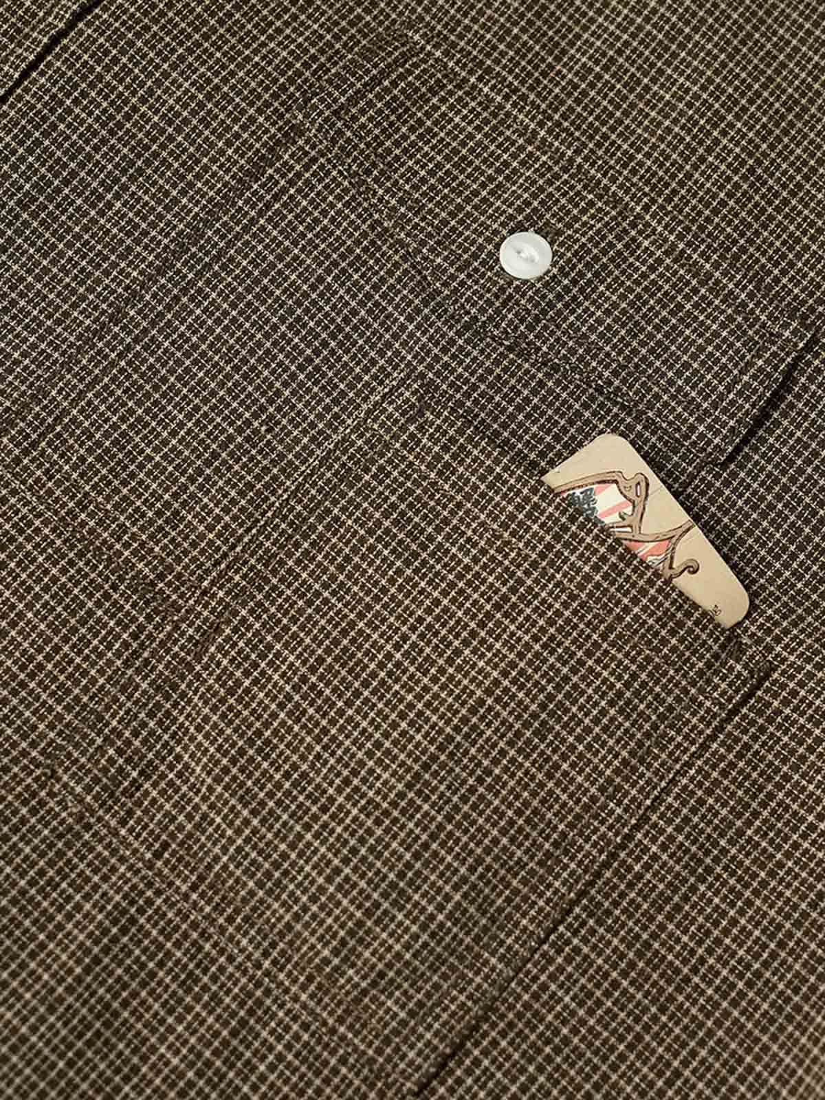 製品画像
「細かいチェック柄とパッチポケットデザインを特徴とする長袖シャツ全体イメージ。コットン100%生地の柔らかさと通気性、自然な落ち感が魅力。」
詳細画像
「胸元のユニークな配置のパッチポケットと立体感のあるチェック柄生地のディテールをクローズアップ。シワになりにくい特性も備えた高品質なコットン素材。」