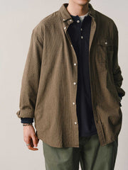 詳細画像
「胸元のユニークな配置のパッチポケットと立体感のあるチェック柄生地のディテールをクローズアップ。シワになりにくい特性も備えた高品質なコットン素材。」
モデル画像
「モデルがネイビーのチェック柄パッチポケットシャツを着用し、デニムパンツと合わせたカジュアルなコーディネートを披露。」