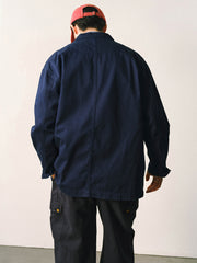 詳細画像
「バイカラーの胸ポケットやアシンメトリーな複合ポケットのディテールクローズアップ。酵素ウォッシュ加工による自然な色褪せ感と軽い起毛感が特徴。」
モデル画像
「モデルがアーミーグリーンのウォッシュ加工ワークテイストテーラードジャケットをデニムと合わせたヴィンテージ風カジュアルワークコーディネート。」