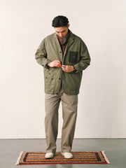 詳細画像
「バイカラーの胸ポケットやアシンメトリーな複合ポケットのディテールクローズアップ。酵素ウォッシュ加工による自然な色褪せ感と軽い起毛感が特徴。」
モデル画像
「モデルがアーミーグリーンのウォッシュ加工ワークテイストテーラードジャケットをデニムと合わせたヴィンテージ風カジュアルワークコーディネート。」