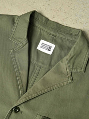 製品画像
「ウォッシュ加工を施したワークテイストテーラードジャケット全体イメージ。スーツのフォーマル感とワークウェアの実用性を融合し、ヴィンテージ感を演出したデザイン。」
詳細画像
「バイカラーの胸ポケットやアシンメトリーな複合ポケットのディテールクローズアップ。酵素ウォッシュ加工による自然な色褪せ感と軽い起毛感が特徴。」