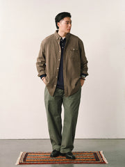 詳細画像
「スラブツイルの竹節模様とヘリンボーンパターンの切り替えデザインをクローズアップ。自然な色褪せ感とパイピング仕上げが高級感を引き立てるディテール。」
モデル画像
「モデルが白シャツとスニーカーを合わせて着用したカーキのヴィンテージ加工スラブ織りテクスチャーパンツのコーディネート。」