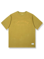デザートイエローの背景にサボテンと野生の花の刺繍が施された「デザートフラワー」半袖Tシャツの正面ビュー。ゆったりとしたフィット感で、夏の日常着に理想的です。