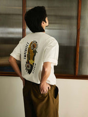 モデルがデザートフラワー刺繍入り半袖Tシャツを着用し、カジュアルショーツとシンプルなスニーカーでコーディネート。個性的でアーティスティックな夏のカジュアルスタイルを演出しています。
