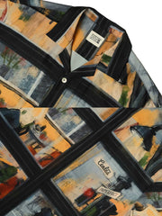 ハワイアンシャツの高精度デジタルプリントのクローズアップ。明瞭で色鮮やかな街景画と天然貝ボタンが、アート作品のようなデザインを際立たせています。