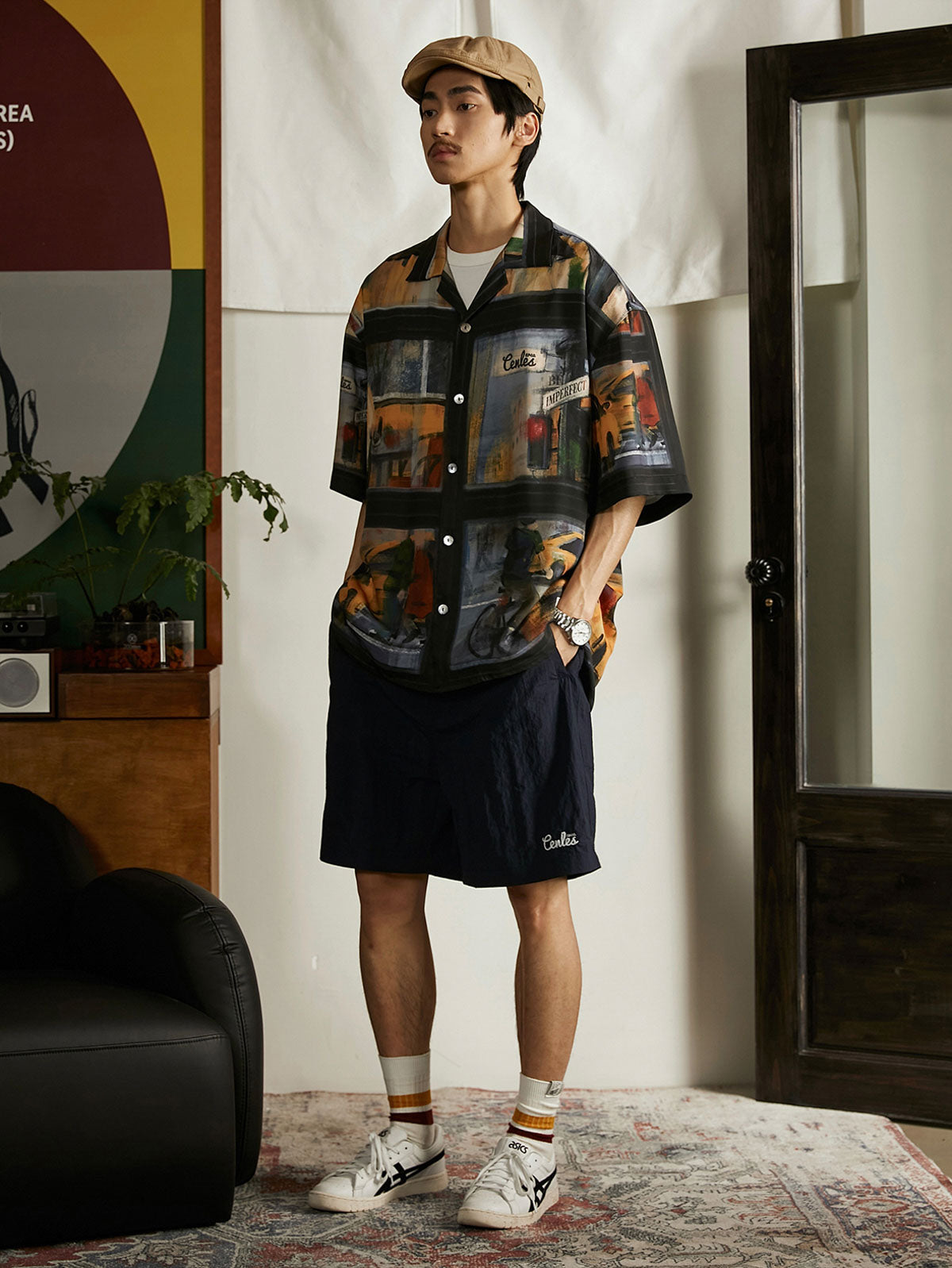 モデルが雨の日の街景油画風ハワイアンシャツを着用し、ジーンズとキャンバスシューズでコーディネート。ダークトーンのプリントがカジュアルながらもアートフルなスタイルを提供し、週末のリラックスしたアウトドアやカジュアルな街歩きに適しています。