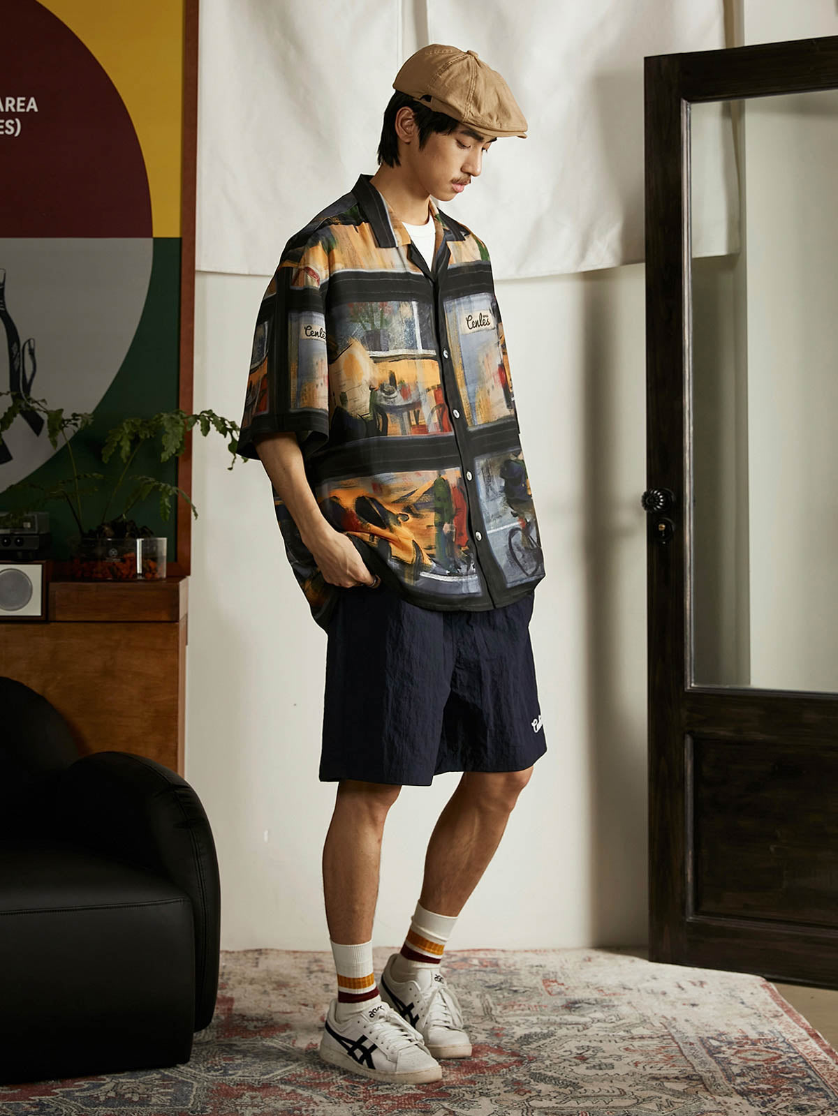 モデルが雨の日の街景油画風ハワイアンシャツを着用し、ジーンズとキャンバスシューズでコーディネート。ダークトーンのプリントがカジュアルながらもアートフルなスタイルを提供し、週末のリラックスしたアウトドアやカジュアルな街歩きに適しています。