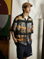 モデルが雨の日の街景油画風ハワイアンシャツを着用し、ジーンズとキャンバスシューズでコーディネート。ダークトーンのプリントがカジュアルながらもアートフルなスタイルを提供し、週末のリラックスしたアウトドアやカジュアルな街歩きに適しています。