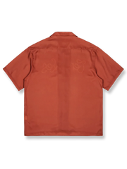 オレンジレッドの背景にレトロプリントが施されたキューバカラーの半袖シャツの正面ビュー。直線的でゆったりとしたカットが特徴で、リラックスしたカジュアルスタイルを提供します。
