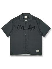 オレンジレッドの背景にレトロプリントが施されたキューバカラーの半袖シャツの正面ビュー。直線的でゆったりとしたカットが特徴で、リラックスしたカジュアルスタイルを提供します。