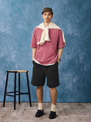 モデルがピンクの重染洗ポケット付きショートスリーブTシャツを着用し、カジュアルパンツとスニーカーでスタイリング。日常や週末のリラックススタイルに最適で、色とデザインがカジュアルながらもスタイリッシュな印象を与えます。