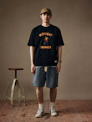 モデルがナイトオウルドリンカープリント半袖Tシャツを着用し、さまざまなスタイルのボトムスと合わせている