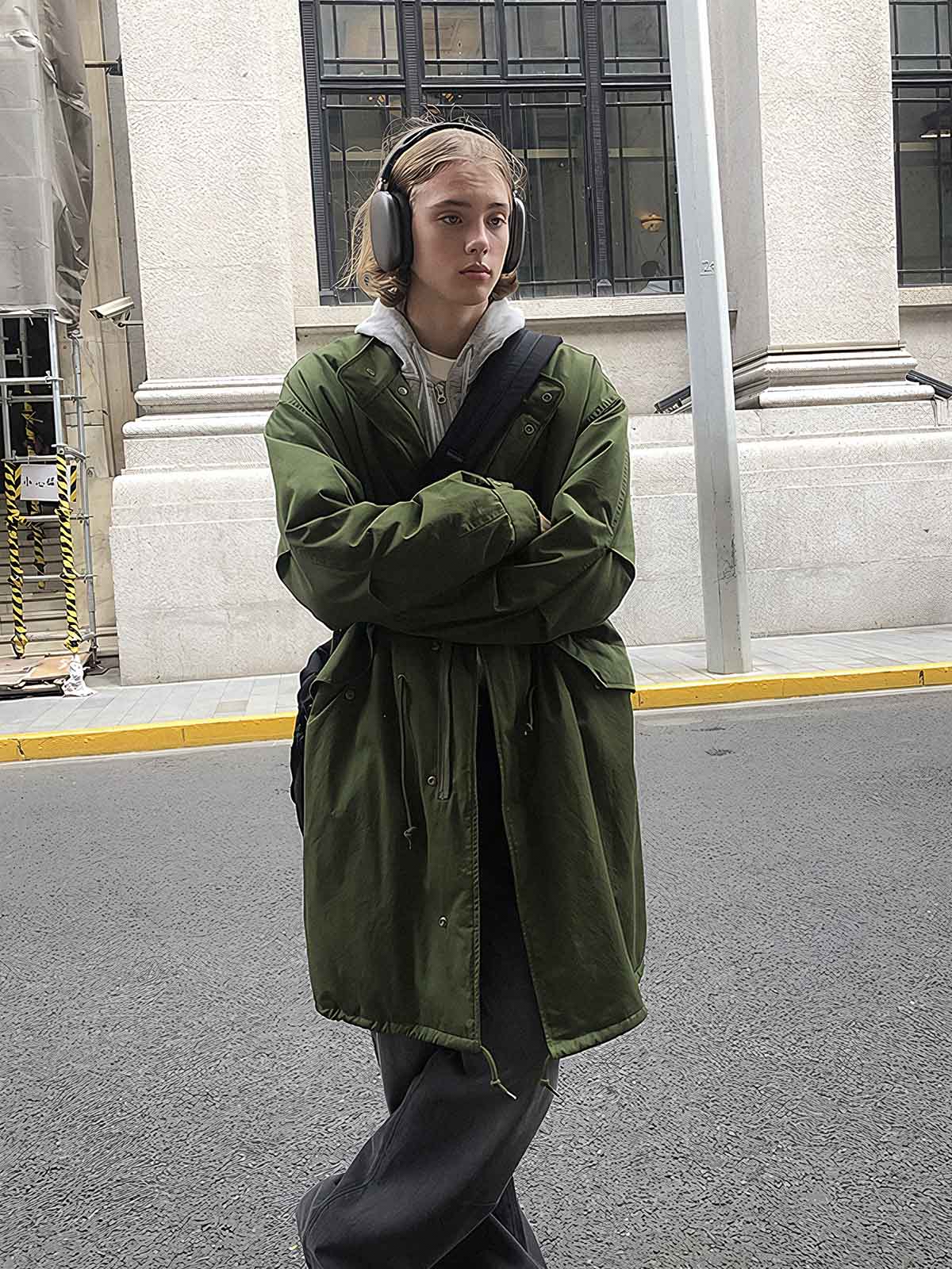 詳細画像: M-65改良型 厚手パーカーコート(ロング)のディテールクローズアップ画像。ウエストライン調整が可能なドローコードと、鍵やスマートフォンなどの収納に便利な多機能ポケットのデザインが映える。防風性を考慮した耐久性の高いコットン素材の質感が際立つ。
モデル画像: モデルが着用した**M-65改良型 厚手パーカーコート(ロング)**の全身コーディネートイメージ。ゆったりとしたシルエットとクラシックなミリタリースタイルを合わせ、ブーツやカジュアルシューズと相性抜群。アウトドアから日常使いまで幅広いシーンに対応する冬のスタイリング例。