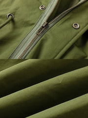 製品画像: M-65改良型 厚手パーカーコート(ロング)の正面全体画像。クラシックなM-65ミリタリーデザインを基に改良されたコートで、厚手の中綿入り構造が保温性を高め、寒冷地にも対応。シンプルながら存在感のあるデザインが特徴。
詳細画像: M-65改良型 厚手パーカーコート(ロング)のディテールクローズアップ画像。ウエストライン調整が可能なドローコードと、鍵やスマートフォンなどの収納に便利な多機能ポケットのデザインが映える。防風性を考慮した耐久性の高いコットン素材の質感が際立つ。