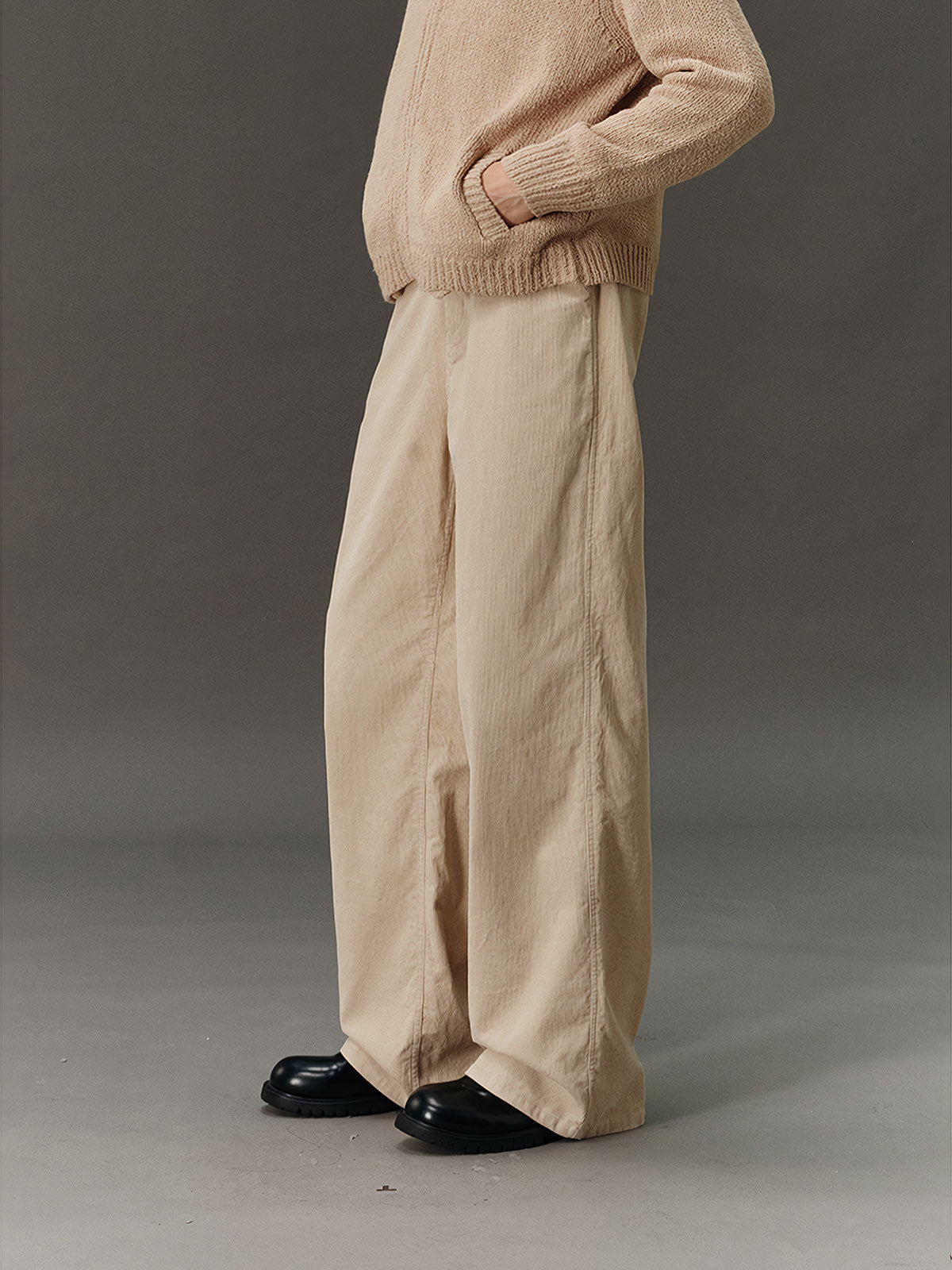 詳細画像: コーデュロイ素材のディテールと裾デザインを映したクローズアップ画像。製品染め加工による深みのあるカラーと、ワイドシルエットの滑らかなラインが際立つ。
モデル画像: モデルが着用したコーデュロイワイドパンツの日常スタイリング例。ヴィンテージ感を漂わせるコーデュロイ素材が、シャツやスウェットとの組み合わせで多用途なスタイルを提供。秋冬のコーディネートに最適。