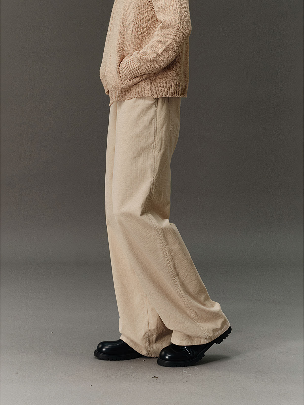 詳細画像: コーデュロイ素材のディテールと裾デザインを映したクローズアップ画像。製品染め加工による深みのあるカラーと、ワイドシルエットの滑らかなラインが際立つ。
モデル画像: モデルが着用したコーデュロイワイドパンツの日常スタイリング例。ヴィンテージ感を漂わせるコーデュロイ素材が、シャツやスウェットとの組み合わせで多用途なスタイルを提供。秋冬のコーディネートに最適。