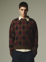 詳細画像: ダイヤ柄の滑らかな編み地のディテールクローズアップ画像。軽量で柔らかい混紡素材が持つ快適さと暖かさを示す。
モデル画像: ダイヤ柄クルーネックニットを着用したモデルによるカジュアルコーディネートイメージ。デニムやワークパンツとの組み合わせでレトロなスタイルを楽しめる。