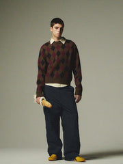 詳細画像: ダイヤ柄の滑らかな編み地のディテールクローズアップ画像。軽量で柔らかい混紡素材が持つ快適さと暖かさを示す。
モデル画像: ダイヤ柄クルーネックニットを着用したモデルによるカジュアルコーディネートイメージ。デニムやワークパンツとの組み合わせでレトロなスタイルを楽しめる。