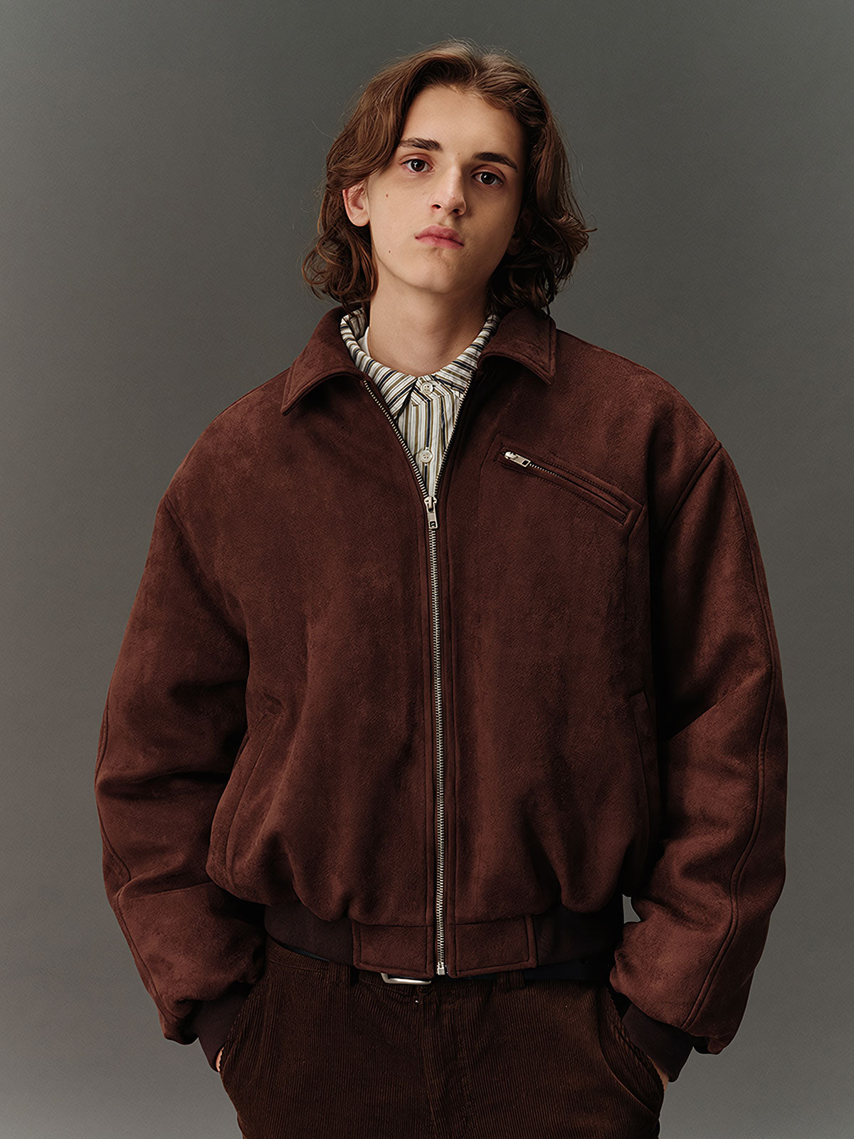 詳細画像: スエード調素材の滑らかな表面とキルティング加工による保温性を示すディテールクローズアップ画像。フラップカラーや多機能ポケットのデザインが際立つ。
モデル画像: スエード調ショート丈ダウンジャケットを着用したモデルのコーディネート例。レトロなブラウンカラーがヴィンテージ感を演出し、カジュアルパンツやワークパンツと相性抜群な秋冬スタイル。