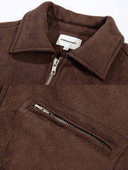 製品画像: スエード調素材を使用したショート丈ダウンジャケットの正面全体画像。上品で滑らかなスエード調の質感が特徴的で、秋冬の防寒にも最適なデザイン。
詳細画像: スエード調素材の滑らかな表面とキルティング加工による保温性を示すディテールクローズアップ画像。フラップカラーや多機能ポケットのデザインが際立つ。